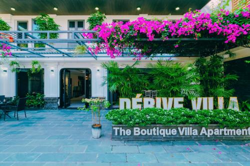 岘港Dérive Boutique Villa & Apartment Da Nang的一座花卉建筑,一个读阴凉别墅的标志