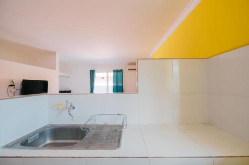 BalianRedDoorz at Kawaii Apartment Jimbaran的厨房设有水槽和黄色天花板