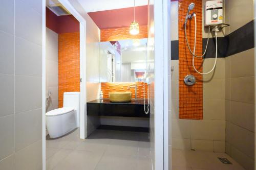 暖武里府Ruen Rattana Resort的带淋浴、盥洗盆和卫生间的浴室