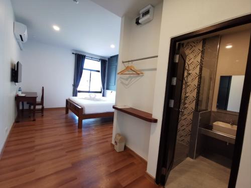 那空拍侬府โรงแรมรชาโขง Racha Khong Hotel的客房设有带一张床的卧室和一间浴室。