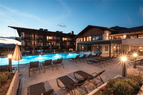 温蒂加斯顿Hotel Sperlhof的一个带椅子的酒店庭院和夜间游泳池