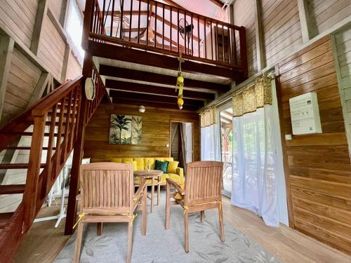 Rivière-PiloteMahogany Lodge - Oasis cosy的一间带桌椅的用餐室和一个阳台