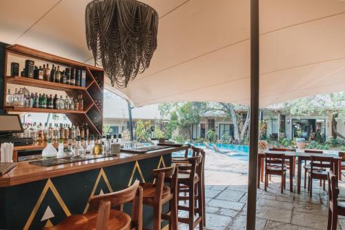 维多利亚瀑布Shongwe Oasis的酒吧位于餐厅内,餐厅后方设有游泳池