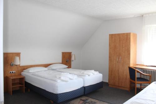 Karlsdorf-NeuthardGasthaus zum Ritter的一间卧室配有两张床、一张桌子和一把椅子