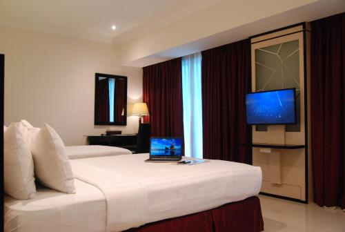名古屋太平洋皇宫酒店的酒店客房,配有一张带笔记本电脑的床