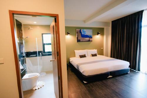 清迈财富精品清迈酒店的一间卧室配有一张床,浴室设有淋浴。