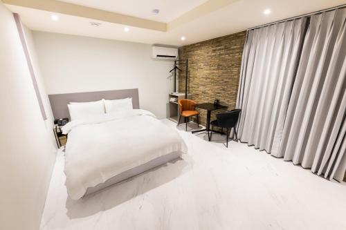釜山HOTEL LENITH Seomyeon的卧室配有白色的床和书桌
