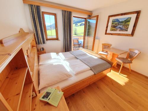 毛特恩多夫Ferienwohnungen Haus-Holzer的一间卧室配有一张床和一张书桌