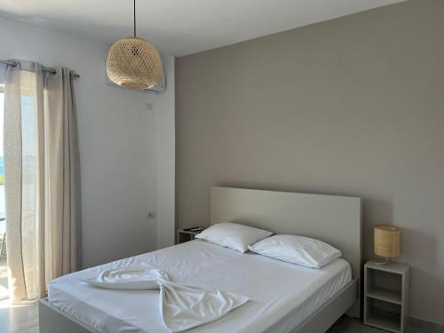 希马拉Koks’ Guesthouse的一间卧室配有一张带白色床单的床和一扇窗户。