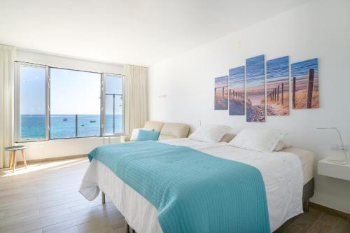 蓬塔穆赫雷斯Casa Roman的一间卧室设有一张床,享有海景