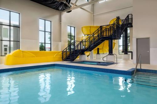 多瓦尔Microtel Inn & Suites Montreal Airport-Dorval QC的一座建筑中带有黄色滑梯的游泳池