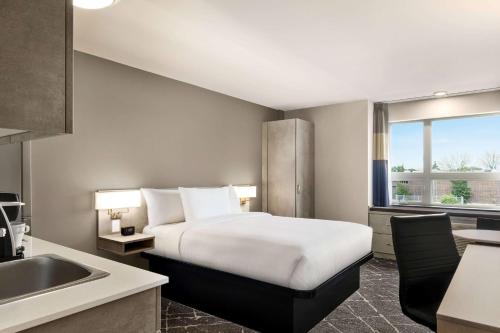 多瓦尔Microtel Inn & Suites Montreal Airport-Dorval QC的酒店客房设有床和水槽