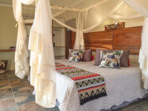 奥乔Okutala Etosha Lodge的一间卧室配有一张带天蓬的床