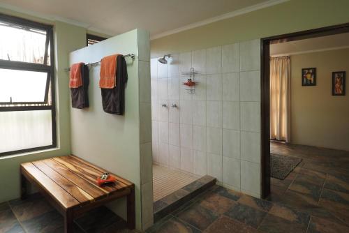 奥乔Okutala Etosha Lodge的带淋浴和木凳的浴室