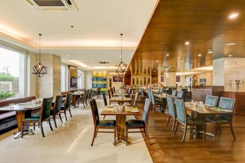 新德里德里机场柠檬树酒店的一间在房间内配有桌椅的餐厅