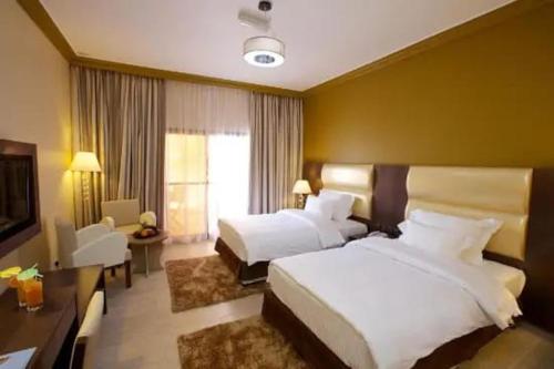 开罗Up Town Hotel的大型酒店客房设有两张床和电视。
