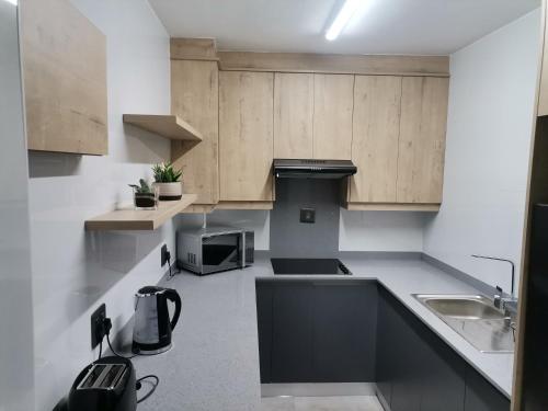 德班Unit 802 Ten South的一个带木制橱柜和水槽的小厨房