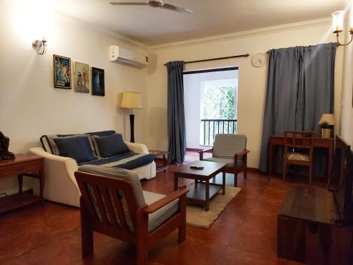 阿伯来Susegad Suites Goa Apartments & Villas Riviera Hermitage Arpora的客厅配有沙发和桌子