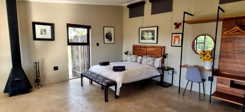马格巴斯科鲁夫Graceland Eco Retreat的一间卧室设有一张大床和一个壁炉