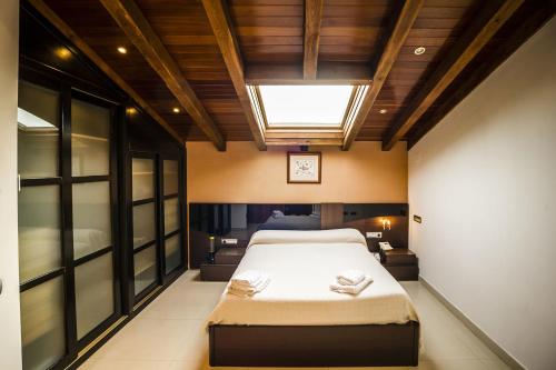AldeatejadaCasa Rural Spa La Chirumba的一间卧室设有一张大床和天窗