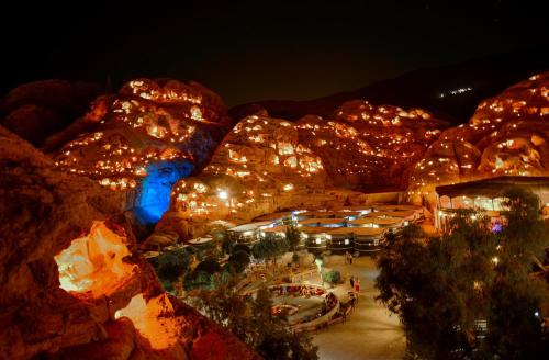 Al Ḩayy小佩特拉贝德营地旅馆的夜间灯光可欣赏到度假村的景色