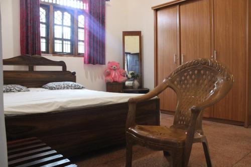 阿努拉德普勒Holiday Home Anuradapura的一间卧室配有一张床和一把椅子