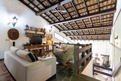 雅卡雷伊Sítio com lazer completo e natureza em Guararema的客厅设有白色沙发和木制天花板