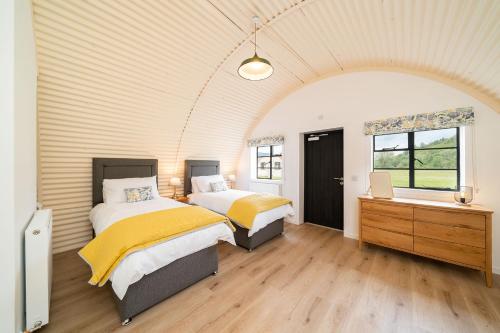 科姆里Cultybraggan Hut 37的客房设有两张床和窗户。