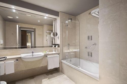 都灵灵格托都灵国会NH酒店的浴室配有水槽、淋浴和浴缸。