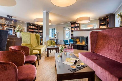 卡劳特格瑞斯赫Logis Hotel QUARTIER 5, Sächsische Schweiz, mit Restaurant, Café & Bar的客厅配有椅子和壁炉