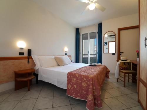 里米尼Dasamo Hotel - Dada Hotels的卧室配有一张白色的大床和一张桌子