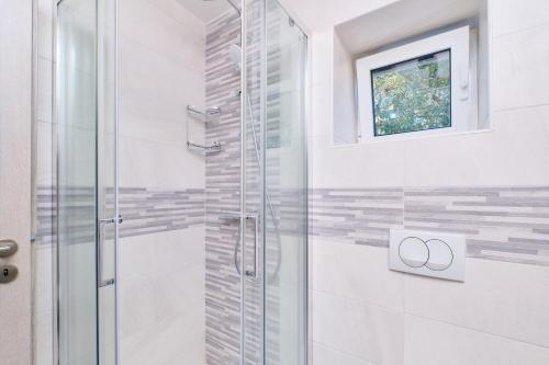 内里吉恩Domus Olivae的浴室设有玻璃淋浴间和窗户