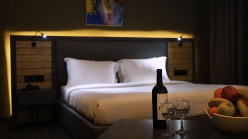 马达巴Aitch Boutique Hotel - an LIH Hotel的一张带一瓶葡萄酒和一碗水果的床