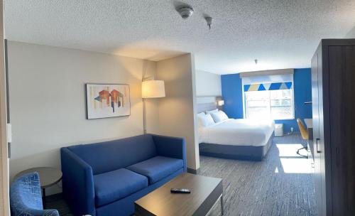 马凯特Holiday Inn Express & Suites Marquette, an IHG Hotel的酒店客房配有蓝色的沙发和床。
