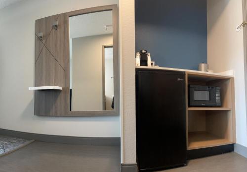 马凯特Holiday Inn Express & Suites Marquette, an IHG Hotel的浴室设有镜子和黑色微波炉