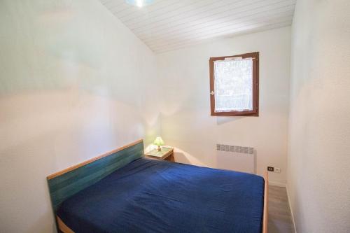 米尼赞海滩A Deux Pas du Courant的一间卧室配有一张带蓝色毯子的床