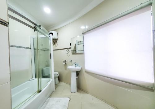 拉各斯Medallion Hotels的带淋浴、卫生间和盥洗盆的浴室