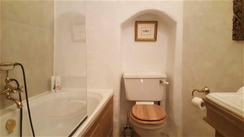 塔林Cozy Old Town Historic House的白色的浴室设有卫生间和浴缸。