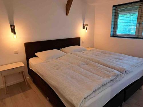 HarelbekeDe Skure: vakantiewoning op boerderij的一间卧室配有一张带白色床单的大床