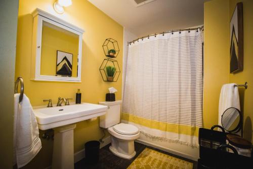 格里利Spacious Loft Over Coffee Shop - Romantic Downtown Escape的黄色的浴室设有水槽和卫生间