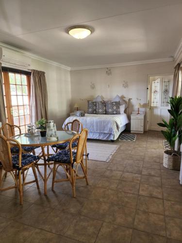 艾伯特王子镇Watervalsrivier Farm的卧室配有一张床和一张桌子及椅子