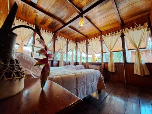 马尔多纳多港Sotupa Eco Lodge的一间带一张床的卧室,位于带木制天花板的房间内