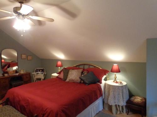 夸利库姆海滩茶壶套住宿&早餐酒店的一间卧室配有红色的床和吊扇