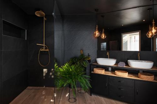 吕特里#Lavaux的黑色浴室设有两个水槽和植物
