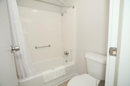 梅肯Travelodge by Wyndham Macon West的白色的浴室设有浴缸和卫生间。