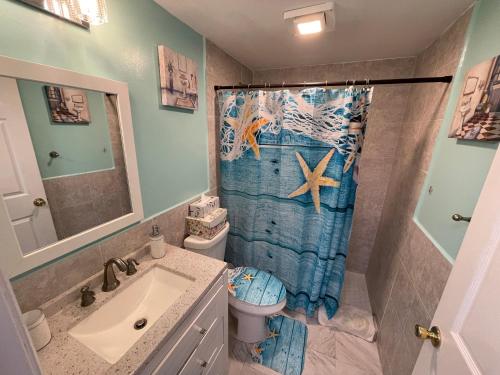 西棕榈滩4BR Downtown House Near Beach, Pet Friendly的浴室设有盥洗盆、卫生间和淋浴帘。