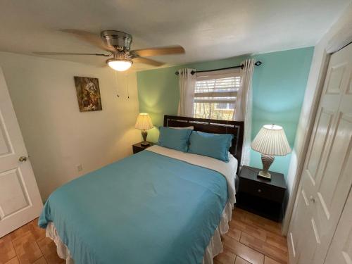 西棕榈滩4BR Downtown House Near Beach, Pet Friendly的一间卧室设有蓝色的床和窗户。
