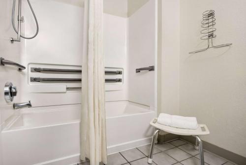 Maysville梅斯维尔速8汽车旅馆的浴室配有白色浴缸和淋浴。