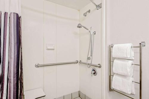 圣安东尼奥圣安东尼奥机场昆塔套房旅馆的带淋浴和白色毛巾的浴室