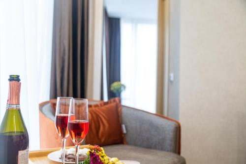 第比利斯Hotel Solum Roof Top的一张桌子,上面放着两杯葡萄酒和一盘食物